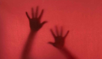 Image of hands behind red veil