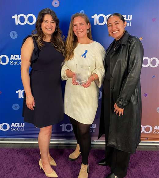UCI Law Immigrant Rights Clinic students Sandra Guzman (’23, left) and Brenda Rosas (rising third-year student, right) pictured with former Clinical Fellow Caitlin Bellis (center) holding the award at the ACLU SoCal Advocates for Justice Reception.